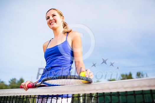 Portrait of a pretty, young tennis player on a court on a lovely summer day Portrait of a pretty, young tennis player on a court on a lovely summer day