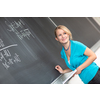 Pretty young college student or teacher washing the chalkboard/blackboa rd during class (shallow DOF; color toned image)