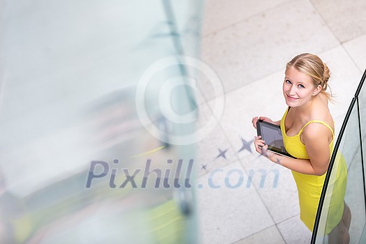 Pretty, young woman using a tablet computer in corporate context Pretty, young woman using a tablet computer in corporate context