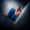 Young woman suffering from a severe depression (very harsh lighting is used on this shot to underline/convey the gloomy mood of the scene)