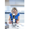 Pretty, female optometrist measuring newly made glasses - veryfing it is spot on