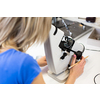 Pretty, female optometrist measuring newly made glasses - veryfing it is spot on
