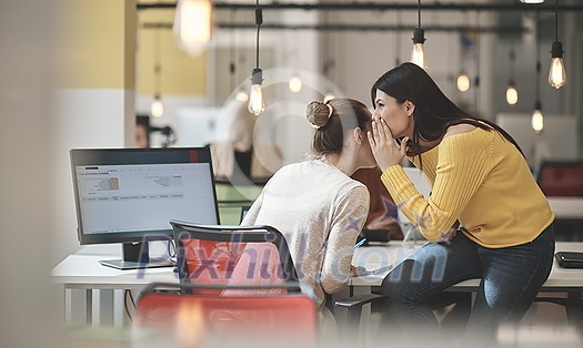 office rumors with two girls whispering in coworking open space startup business office office rumors with two girls whispering in coworking open space startup business office