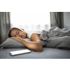 Pretty, young woman sleeping in her bed with her cell phone close to her. Smartphone in Bed Mobile/smartphone  Addiction Concept.