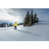 Young man snowshoeing in high mountains, enjoying splendid winter weather with abundance of snow