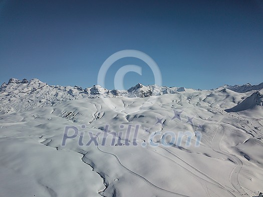 Snow covered winter sports resort in Swiss Alps - aerial image Snow covered winter sports resort in Swiss Alps - aerial image