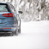 Car on a snowy winter road amid forests - using its four wheel drive capacities to get through the snow