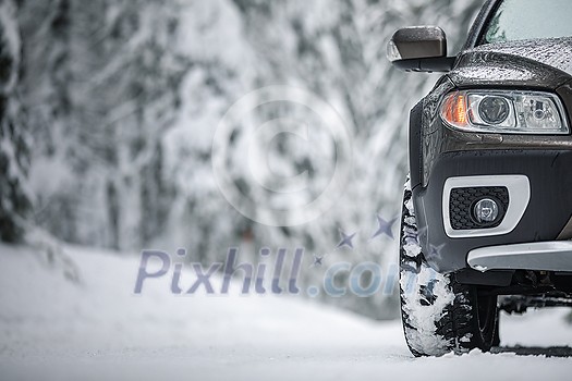 Car on a snowy winter road amid forests - using its four wheel drive capacities to get through the snow Car on a snowy winter road amid forests - using its four wheel drive capacities to get through the snow