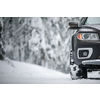 Car on a snowy winter road amid forests - using its four wheel drive capacities to get through the snow