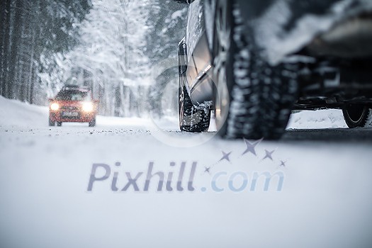 Car on a snowy winter road amid forests - using its four wheel drive capacities to get through the snow Car on a snowy winter road amid forests - using its four wheel drive capacities to get through the snow