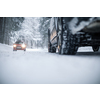 Car on a snowy winter road amid forests - using its four wheel drive capacities to get through the snow