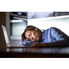 Middle-aged woman working late in the day on a laptop computer at home, running a business from home/working remotely for a corporation