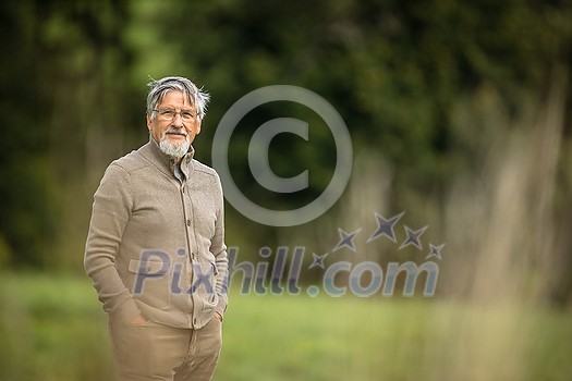 Senior man enjoying the outdoors, hiking, walking throught lovely nature Senior man enjoying the outdoors, hiking, walking throught lovely nature