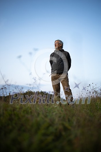 Senior man enjoying the outdoors, hiking, walking throught lovely nature Senior man enjoying the outdoors, hiking, walking throught lovely nature
