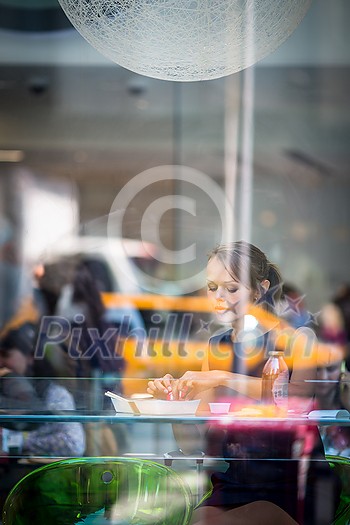 Pretty, young woman eating sushi in a restaurant, having her lunch break, enjoying the food, pausing for a while from her busy corporate/office life (color toned image) Pretty, young woman eating sushi in a restaurant, having her lunch break, enjoying the food, pausing for a while from her busy corporate/office life (color toned image)