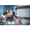 Pretty, young woman eating sushi in a restaurant, having her lunch break, enjoying the food, pausing for a while from her busy corporate/office life (color toned image)