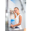 Pretty, young woman in her modern, clean and bright kitchen, fixing lunch (color toned imagey; shallow DOF)