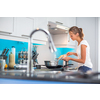 Pretty, young woman in her modern, clean and bright kitchen, fixing lunch (color toned imagey; shallow DOF)