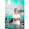 Senior man standing in his renovated, modern kitchen,