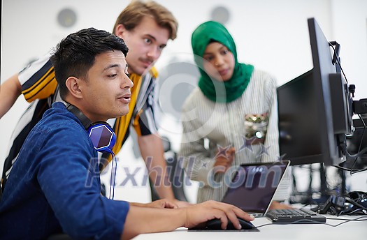 Multiethnic startup business team Arabian woman wearing a hijab on meeting in modern open plan office interior brainstorming, working on laptop and desktop computer Multiethnic startup business team Arabian woman wearing a hijab on meeting in modern open plan office interior brainstorming, working on laptop and desktop computer