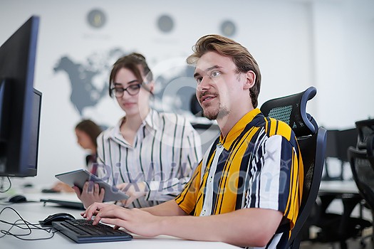 business couple working together on project using tablet and desktop computer at modern open plan startup office business couple working together on project using tablet and desktop computer at modern open plan startup office