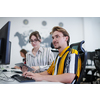 business couple working together on project using tablet and desktop computer at modern open plan startup office
