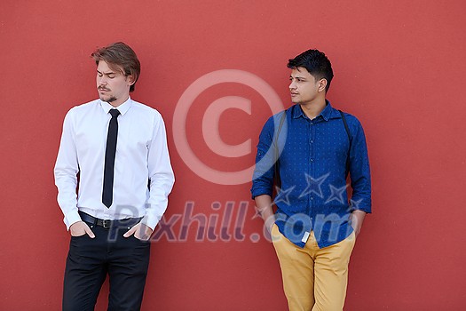 portrait of casual multiethnic startup business men one of them is indian during break from work in front of pink wall outside portrait of casual multiethnic startup business men one of them is indian during break from work in front of pink wall outside