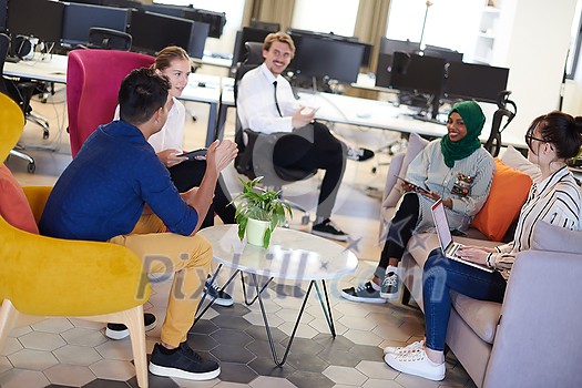 Multiethnic startup business team having brainstorming in relaxation area of modern office interior working on laptop and tablet computer Multiethnic startup business team having brainstorming in relaxation area of modern office interior working on laptop and tablet computer