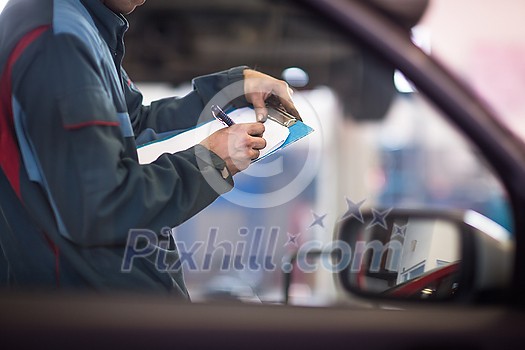 Inside a garage - mechanic carrying out repairs (shallow DOF; color toned image) Inside a garage - mechanic carrying out repairs (shallow DOF; color toned image)