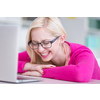 Pretty young college student in a library laughing in front of her laptop computer (shallow DOF; color toned image)