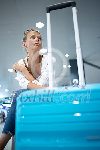 Young woman with her luggage at an international airport, before going through the check-in and the security check before her flight Young woman with her luggage at an international airport, before going through the check-in and the security check before her flight