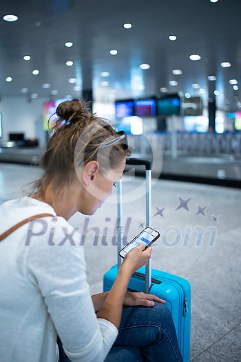 Young woman with her luggage at an international airport, before going through the check-in and the security check before her flight Young woman with her luggage at an international airport, before going through the check-in and the security check before her flight