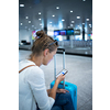 Young woman with her luggage at an international airport, before going through the check-in and the security check before her flight