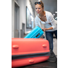 Young woman with her luggage at an international airport, waiting for her luggage to arrive at the baggage claim zone