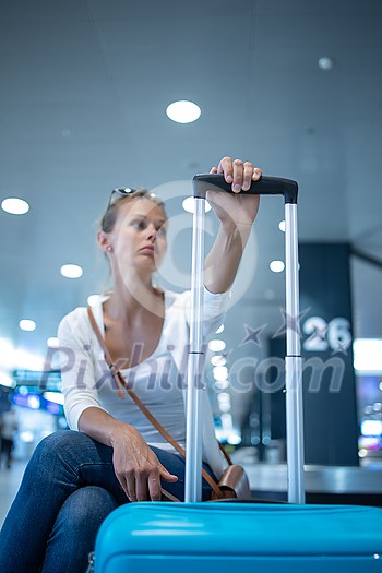 Young woman with her luggage at an international airport, before going through the check-in and the security check before her flight Young woman with her luggage at an international airport, before going through the check-in and the security check before her flight