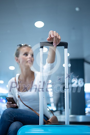 Young woman with her luggage at an international airport, before going through the check-in and the security check before her flight Young woman with her luggage at an international airport, before going through the check-in and the security check before her flight