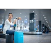 Young woman with her luggage at an international airport, before going through the check-in and the security check before her flight