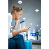 Young woman with her luggage at an international airport, before going through the check-in and the security check before her flight