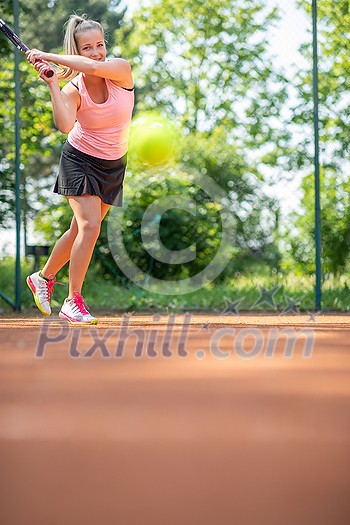 Pretty, young woman tennis player playing on a clay court. Healthy active lifestyle concept Pretty, young woman tennis player playing on a clay court. Healthy active lifestyle concept