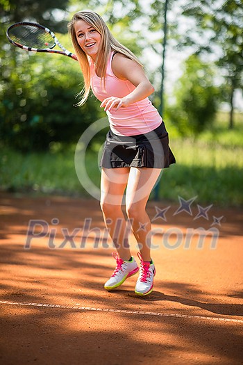 Pretty, young woman tennis player playing on a clay tennis court. Healthy active lifestyle concept Pretty, young woman tennis player playing on a clay tennis court. Healthy active lifestyle concept