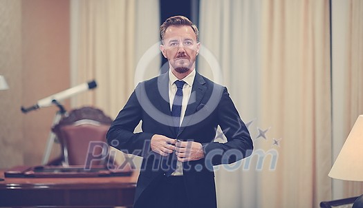 Senior executive businessman at luxury corporate workspace. Portrait of smiling ceo at modern office in stylish suit Senior executive businessman at luxury corporate workspace. Portrait of smiling ceo at modern office in stylish suit