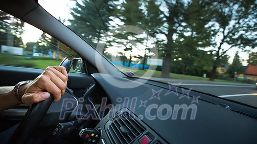 Hands of a driver on a wheel of a car (motion blurred image) Hands of a driver on a wheel of a car (motion blurred image)