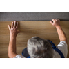 DIY, repair, building and home concept - close up of male hands lying parquet floor board/laminate flooring (shallow DOF; color toned image)