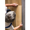DIY, repair, building and home concept - close up of male hands lying parquet floor board/laminate flooring (shallow DOF; color toned image)