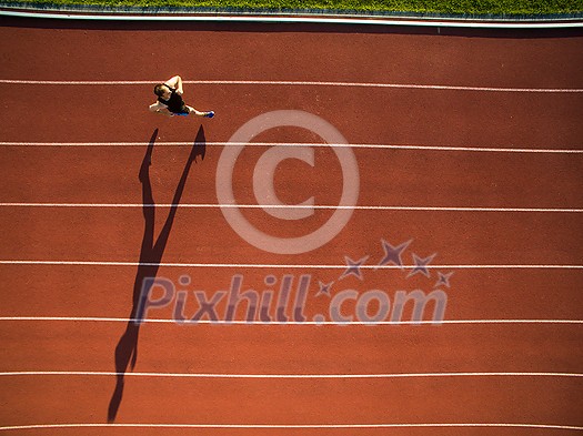 Shot of a young male athlete training on a race track. Sprinter running on athletics tracks seen from above Shot of a young male athlete training on a race track. Sprinter running on athletics tracks seen from above
