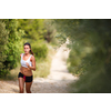 Beautiful young female runner on a forest path, on a lovely summer day