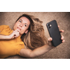 Happy mid-aged woman taking selfie with her smart phone at home