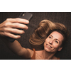 Happy mid-aged woman taking selfie with her smart phone at home