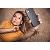 Happy mid-aged woman taking selfie with her smart phone at home