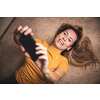 Happy mid-aged woman taking selfie with her smart phone at home